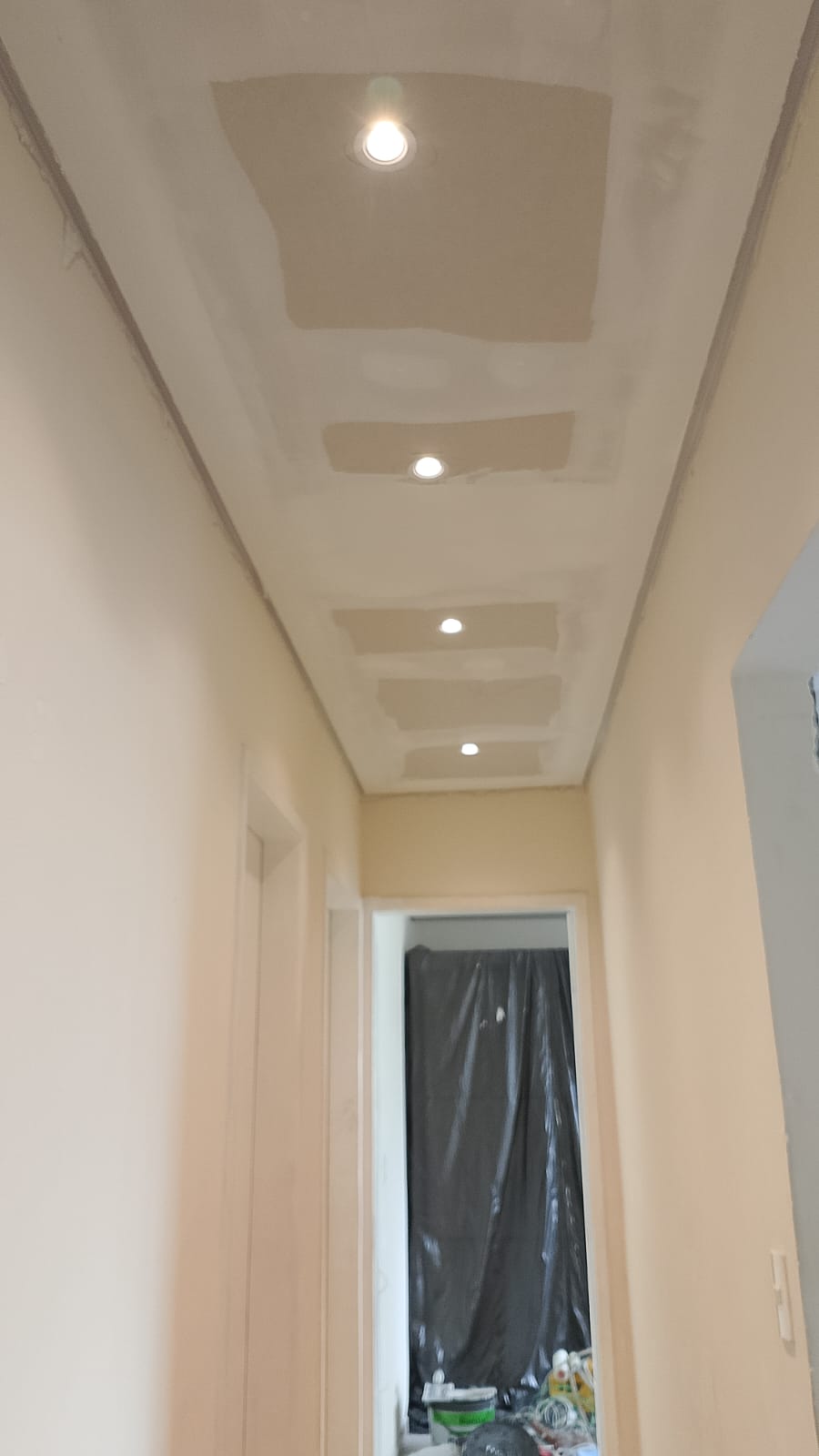 Teto rebaixado em construção com iluminação embutida.